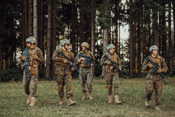 Soldier fighters standing together with guns. Group portrait of US army elite members, private military company servicemen, anti terrorist squad