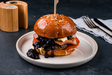 American food beef burger with pork, tomatoes, cabbage, blue cheese and blackcurrant jam.