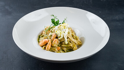 Lunch pasta with cream cheese, shrimp, pesto and green peas.