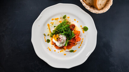 Breakfast poached egg with salmon, red caviar, avocado, tomatoes, arugula, spinach and green peas.