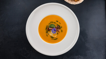 Pumpkin cream soup with champignons and greens.