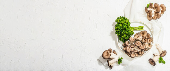 Fresh oyster mushrooms on a ceramic plate with parsley. Healthy ingredient for cooking vegan food