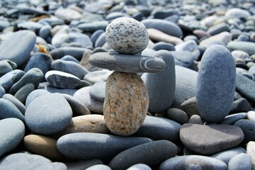 Fototapeta na wymiar A tower of pebbles on a stony beach. Zen stones.