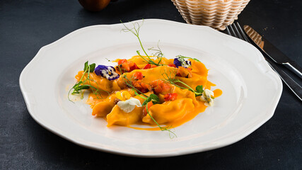 Italian cuisine Ravioli with gorgoznola, pear, sauce and microgreens.