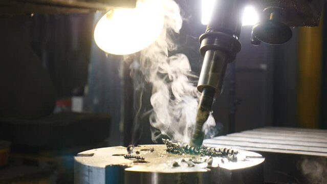Drilling hole in metal surface. Spinning drill beet among metal shavings. High hardness diamond coated beet drilling. Craftsman equipment. Professional tool. Handcraft. Close-up. 4 k video