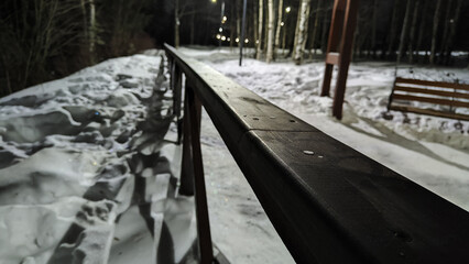 Long black railings of fence on a winter night and white snow all around. Partial focus and distant blur - Powered by Adobe