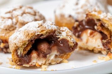 Freshly baked cream puffs. Eclair cake with cream and chocolate filling. Close up