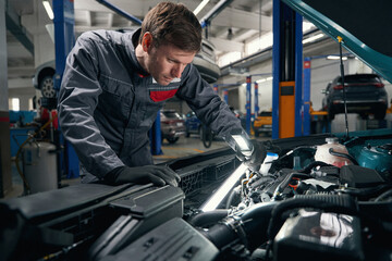 Fototapeta premium Worker conducts full technical check of auto