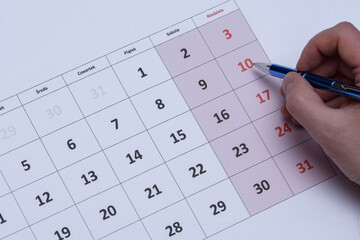Kalendarz z długotrzymanym w dłoni, który wskazuje dziesiąty dzień miesiąca 