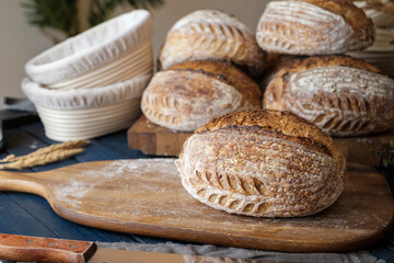 Artisan Batard Sourdough healthy Bread with leaf scoring. Open crumb high hydration Sourdough bread set on white table. - 579360312