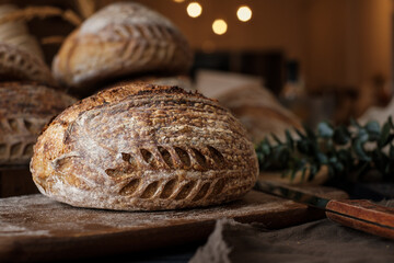 Artisan Batard Sourdough healthy Bread with leaf scoring. Open crumb high hydration Sourdough bread set on white table. - 579360314