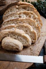 Artisan Batard Sourdough healthy Bread with leaf scoring. Open crumb high hydration Sourdough bread set on white table. - 579360327