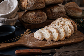 Artisan Batard Sourdough healthy Bread with leaf scoring. Open crumb high hydration Sourdough bread set on white table. - 579360333