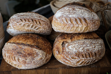 Artisan Batard Sourdough healthy Bread with leaf scoring. Open crumb high hydration Sourdough bread set on white table. - 579360335