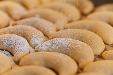 close up off vanilla crescents beeing dusted with powdered sugar