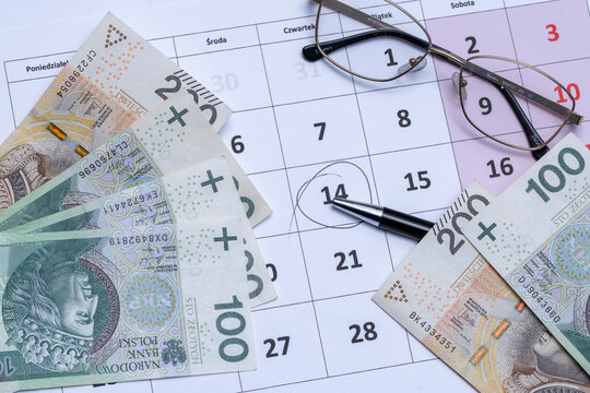 Kalendarz z zaznaczonym terminem, polską got&oacute;wką,  długopisem i okularami