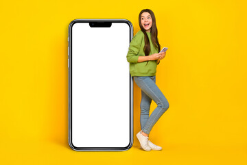 Full body profile side photo of young excited lady use mobile look empty space menu panel isolated over yellow color background