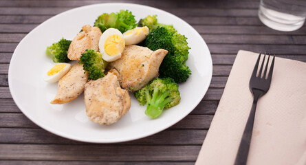healthy appetizer of chicken pieces with broccoli and quail eggs in bowl for healthy lunch
