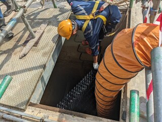 Worker install settler for oil on oil sparator pit with confine space. The photo is suitable to use for safety poster and safety content media. - obrazy, fototapety, plakaty