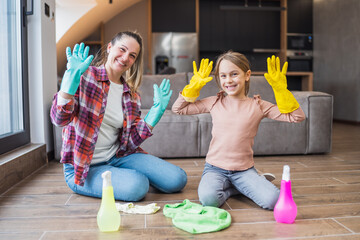 Happy mother and daughter cleaning house together.