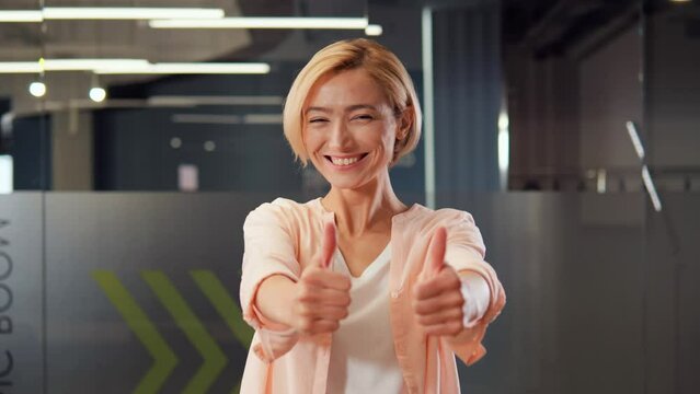 Cheerful, lively blonde girl dances beautifully in office, creating a bright and positive atmosphere that she loves to share with those around her. Her movements are skillful and graceful, showing ok.