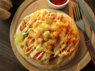 Sausage and ham pizza, tomato sauce, on a wooden tray