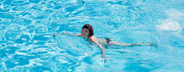 Young successful business woman bathes in her own pool.