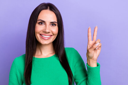 Closeup photo of attractive model lady wear green sweater show v-sign peace symbol stop war ukraine isolated on pastel violet color background