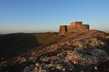 Eine Burg auf der Insel Lanzarote im warmen Licht des Sonnenaufganges.