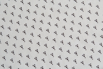 Fabric with a repeating geometric pattern. Black shapes on white cloth. 