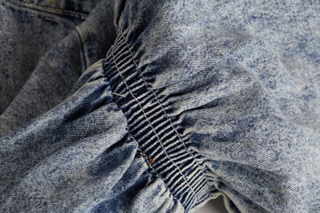 Cinched fabric detail. Blue bleached denim material. - obrazy, fototapety, plakaty