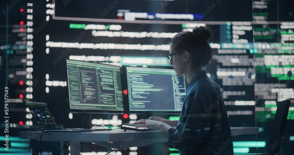 Fototapete Female Developer Thinking and Typing on Computer, Surrounded by Big Screens Showing Coding Language. Professional Programmer Working in a Modern Office, Running Coding Tests. Futuristic Programming