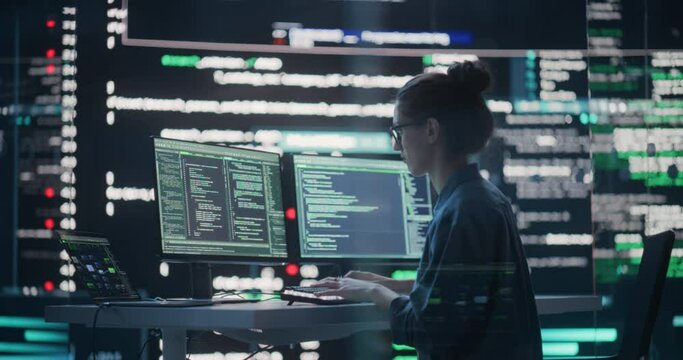 Female Developer Thinking and Typing on Computer, Surrounded by Big Screens Showing Coding Language. Professional Programmer Working in a Modern Office, Running Coding Tests. Futuristic Programming