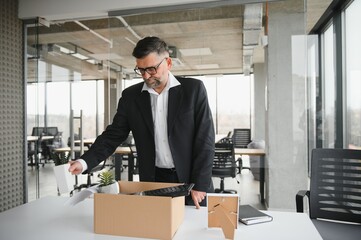 old employee leaving office with the box full of belongings