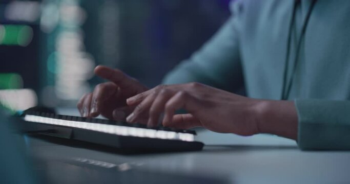 Black Male Developer Smiling Happily After Successfully Typing on Computer a Functioning Software Code. Tracking Shot from Hand to Face of Professional Programmer Collaborating Online with Colleagues