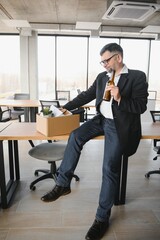 Portrait of sad dismissed senior old business man worker taking his office supplies in the box. Pensioner mature retire from work carry staff back home. Lifestyle business retirement, quit job concept