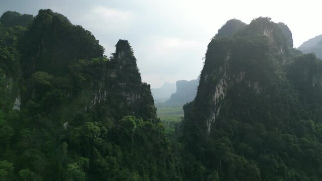 Aerial view scenery fly between beautiful mountains in untouched tropical jungle. Cinematic video drone flight in mountainous scenery over green authentic wild jungle