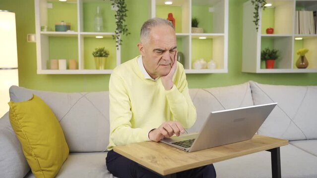 The old man who has trouble using a laptop at home is away from technology.
At home, the old man does not use a laptop, he does his work on the Internet, he has difficulties.
