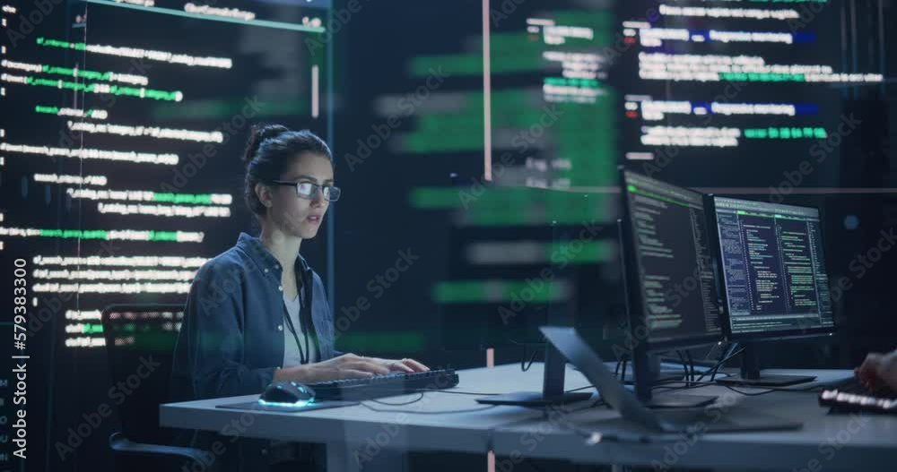 Fototapete Portrait of Two Colleagues Working in a Monitoring Room, Surrounded by Big Screens Displaying Lines of Programming Language Code. Professional Hackers Breaking Through Cybersecurity Protection System