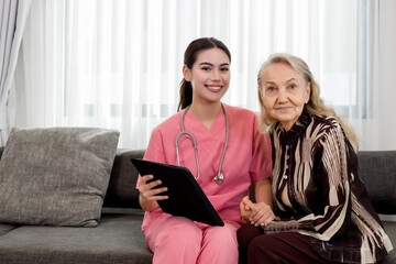 Caucasian caregiver lady consulting with elderly woman patient. Happy old mature man sitting on couch sofa talking to nurse at nursing home. Healthcare support with senior woman for medical help.