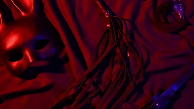 Set of erotic sex toys for adults. Leather whip flogger, handcuffs and rabbit mask for BDSM sex with submission and domination