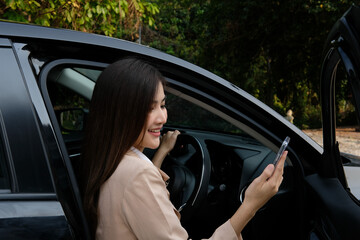 Lady looking at phone near car