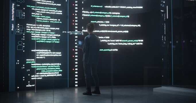 Portrait of Young Woman Working on Laptop Computer, Looking at Big Digital Screen Displaying Back-end Code Lines. Professional Programmer Developing a Big Data Interface Software Project