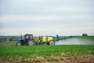 Foto op Canvas Tractor with mounted sprayer, farmer crop spraying. Tractor spraying pesticides on vegetable field with sprayer. Agricultural tractor spraying field. Tractor fertilize field pesticide and insecticide © Tricky Shark