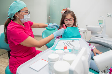 Female dentist with a young girl in her office after dental treatment