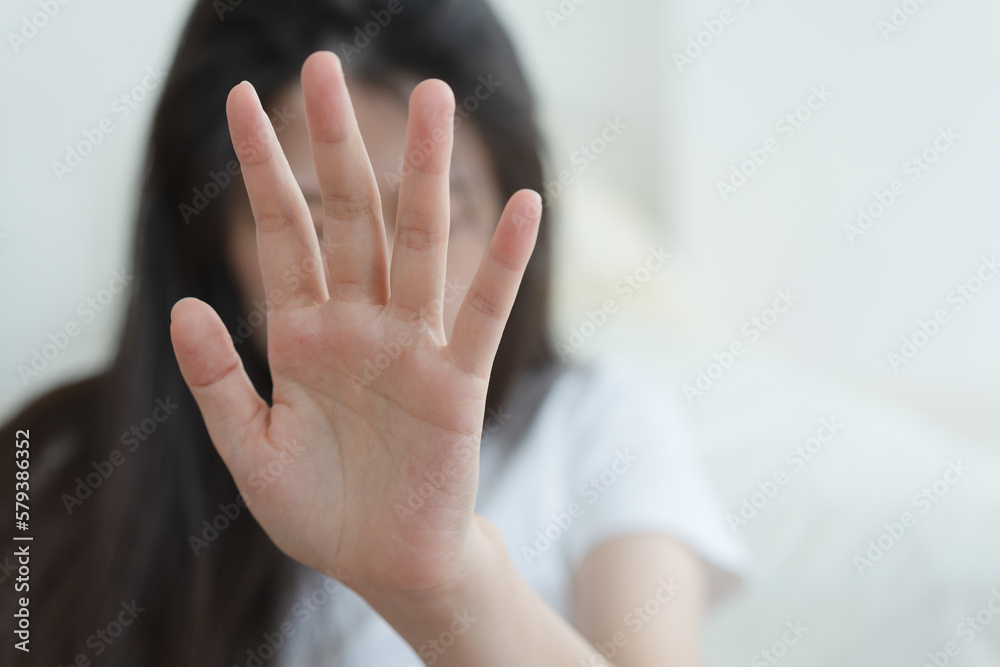 Wall mural woman making frightened gesture with her palms as if trying to defend herself from someone