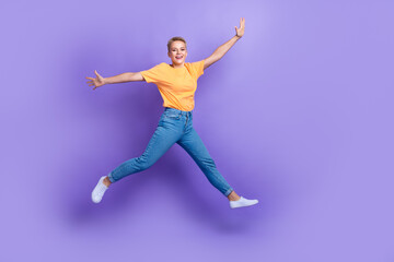 Fototapeta na wymiar Full body portrait of overjoyed sportive lady jumping raise hands good mood isolated on purple color background