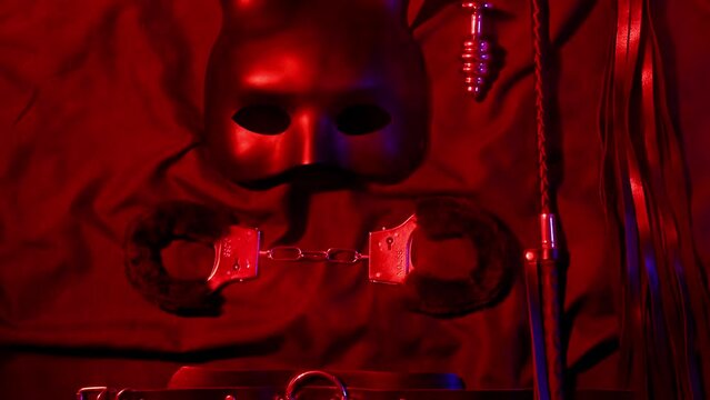 Set of erotic sex toys for adults. Handcuffs, leather whip flogger, mask, choker and butt plug for sex with domination and submission