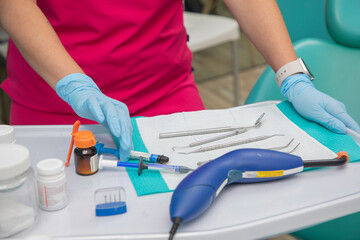 Close up of the hands of a dentist accommodating a set of dental instruments