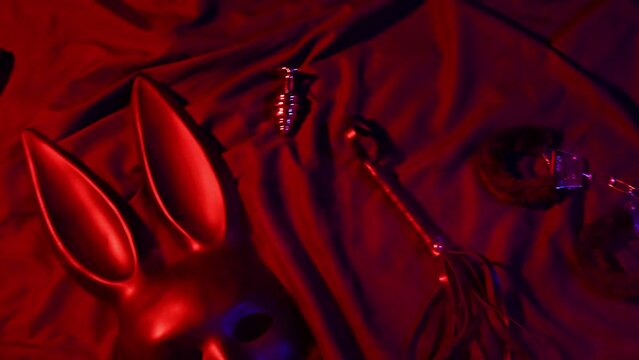 Set of erotic sex toys for adults. Handcuffs, leather whip flogger, mask, choker and butt plug for sex with domination and submission